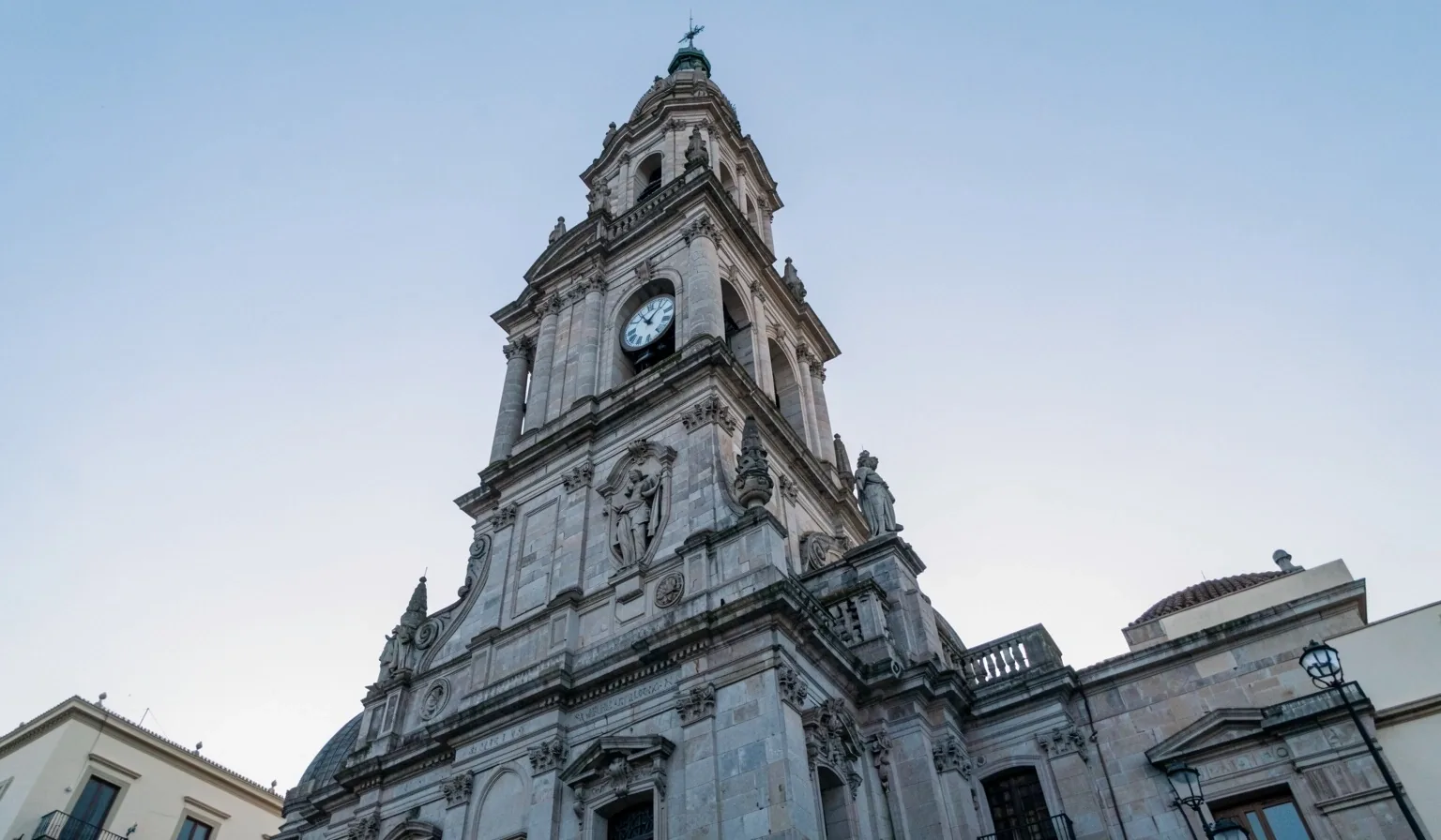 Torre de reloj de edificio institucional español contra el cielo del amanecer